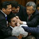 Opposition lawmakers try to cover the face of Masahisa Sato, deputy chairman of the upper chamber special committee on security legislation. EPA/Kimimasa Mayama.